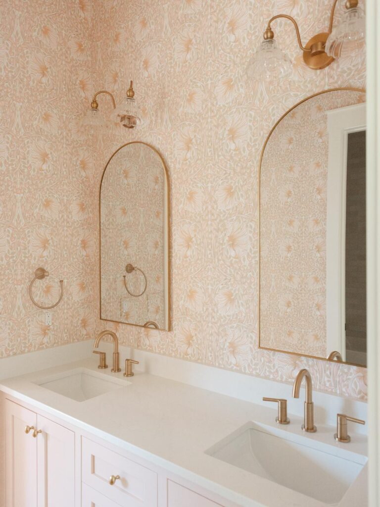 pink bathroom with wallpaper and double vanity 
